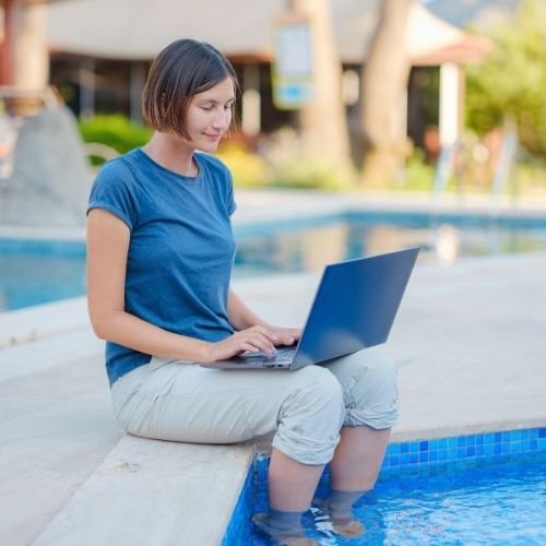 Mujer joven conectando con la fibra vacacional de Zafiro Telecom en una piscina.